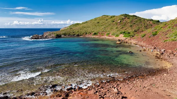 Cala Pregonda con arena roja y aguas claras, norte de Menorca