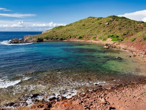 Cala Pregonda con arena roja y aguas claras, norte de Menorca