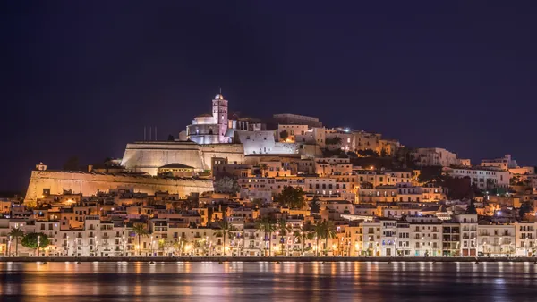 Vista panorámica de Ibiza con las luces reflejadas en el agua.