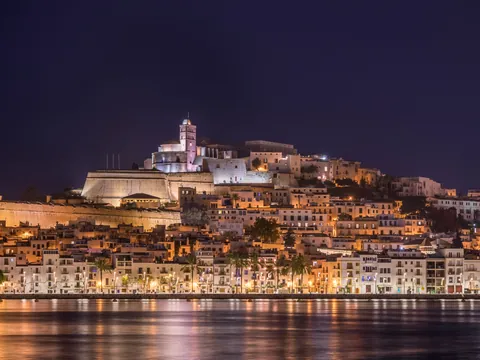 Vista panorámica de Ibiza con las luces reflejadas en el agua.