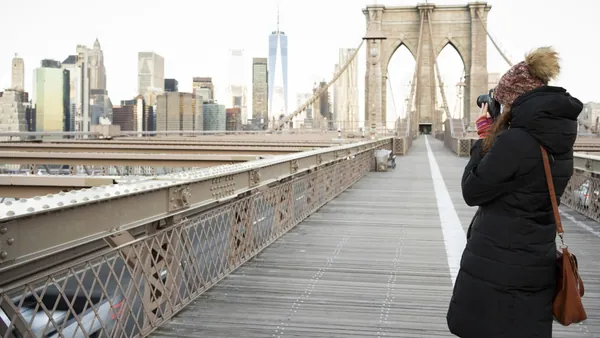 Persona fotografiando el Puente de Brooklyn con skyline de Nueva York, Estados Unidos