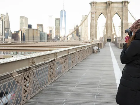 Persona fotografiando el Puente de Brooklyn con skyline de Nueva York, Estados Unidos