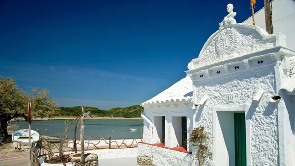 Fachada de casa blanca tradicional en el puerto de Es Grau, Menorca