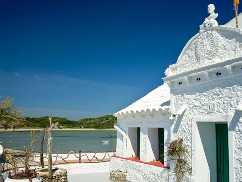 Fachada de casa blanca tradicional en el puerto de Es Grau, Menorca