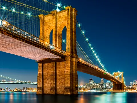 **Alt sugerido (≤80 caracteres):** Puente de Brooklyn iluminado de noche con el skyline de Nueva York