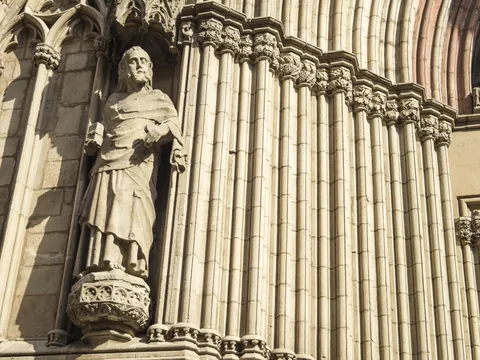 Escultura de figura religiosa en la fachada gótica de la Catedral de Santa María del Mar en Barcelona, con columnas ornamentadas.