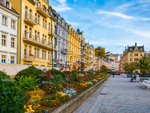 Fila de edificios coloridos y fuente de agua en la calle principal de Karlovy Vary.