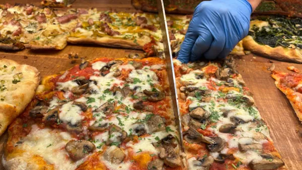 Pizzero italiano cortando una pizza con purchetta, otra de las recetas típicas que se prueban en este tour gastronómico por el barrio de Trastevere.