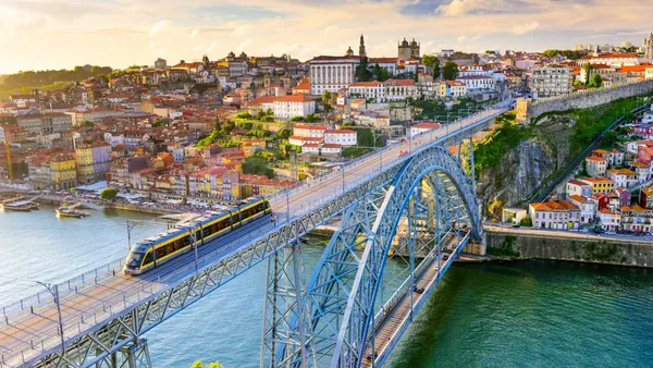 Puente Don Luis I con tranvía cruzando el río Duero al atardecer en Oporto.