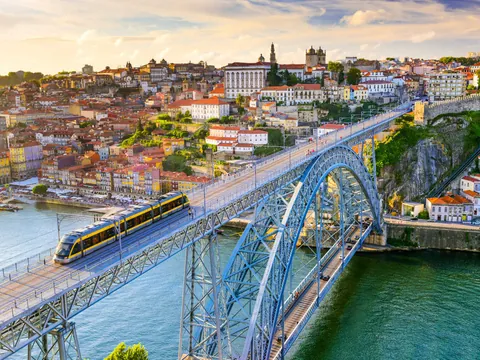 Puente Don Luis I con tranvía cruzando el río Duero al atardecer en Oporto.