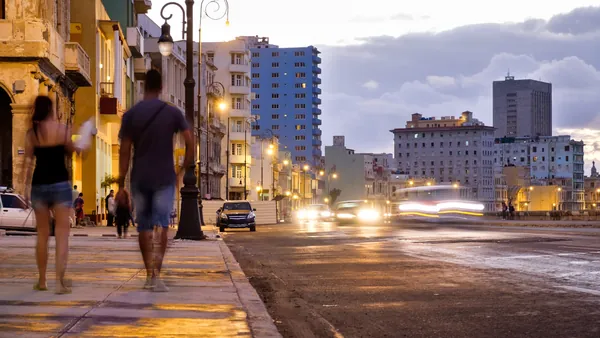 Pareja caminando al atardecer por La Habana, en una ruta de bares y baile