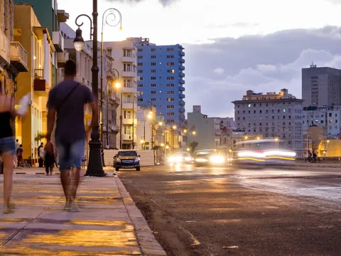 Pareja caminando al atardecer por La Habana, en una ruta de bares y baile