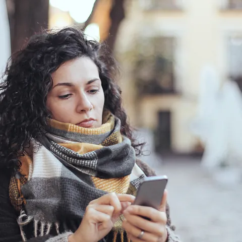 Mujer mirando su teléfono en Sevilla