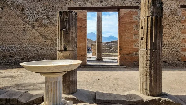 Ruinas de la antigua ciudad romana de Pompeya, Italia, con el Monte Vesubio visible al fondo.