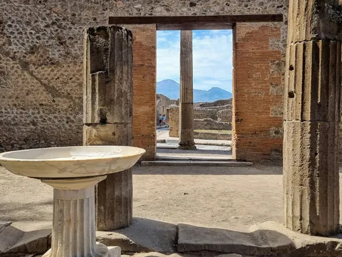 Ruinas de la antigua ciudad romana de Pompeya, Italia, con el Monte Vesubio visible al fondo.