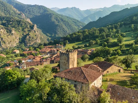Vista aérea de Mogrovejo con su torre medieval entre montañas en Cantabria