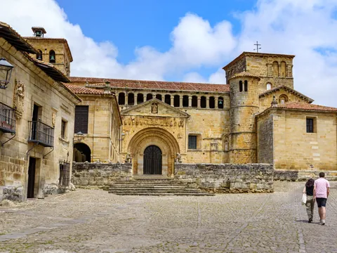 Pareja paseando delante de la Iglesia en Santillana del Mar