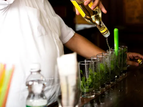 Camarero sirviendo mojitos en la ruta de bares en La Habana