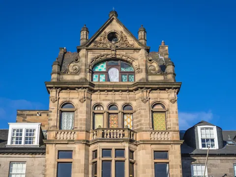 Vista de un edificio histórico en New Town, con su elegante fachada georgiana de piedra y detalles arquitectónicos clásicos.