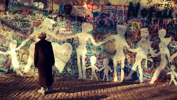 Persona admirando el icónico Muro de John Lennon en Praga.