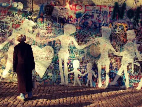Persona admirando el icónico Muro de John Lennon en Praga.