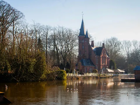 Vista del Lago del Amor en Brujas, Bélgica, con su icónico edificio rojo reflejado en el agua