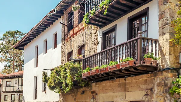 Balcón tradicional con flores en una casona de Santillana del Mar, Cantabria.