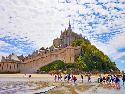 Claustro ajardinado y fachada gótica de la abadía del Mont Saint-Michel en Normandía, Francia.