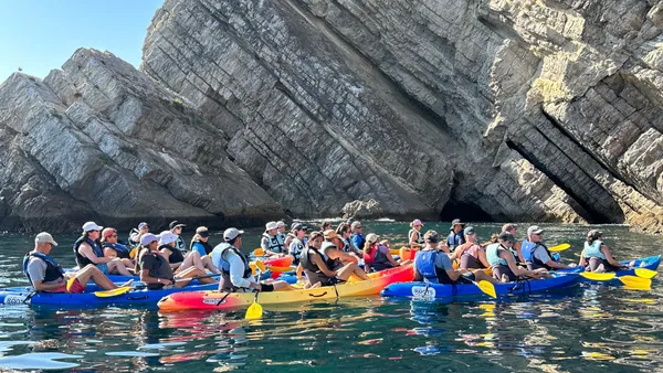 Kayaks detenidos para escuchar al guía durante el recorrido por la costa portuguesa.