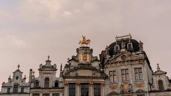 Edificio histórico en la Grand Place de Bruselas con estatua dorada de un caballo en la cima.