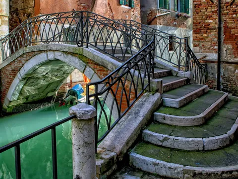 Puente sobre canal en Venecia con escaleras y barandales de hierro