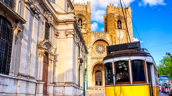 Tranvía circulando con la catedral de Lisboa al fondo en el barrio de Alfama