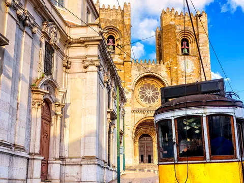 Tranvía circulando con la catedral de Lisboa al fondo en el barrio de Alfama
