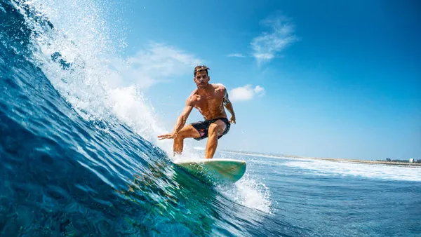 Surfista manteniendo el equilibrio en la ola, clases de surf en Llanes