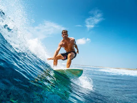 Surfista manteniendo el equilibrio en la ola, clases de surf en Llanes