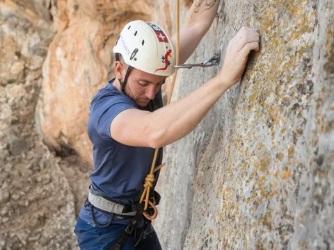 Hombre escalando una pared de roca en El Chorro, cerca del Caminito del Rey