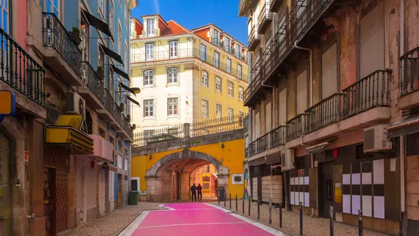 La famosa Calle Rosa de Lisboa, bajo un arco amarillo en el Barrio Alto.