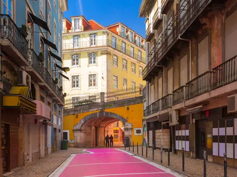 La famosa Calle Rosa de Lisboa, bajo un arco amarillo en el Barrio Alto.
