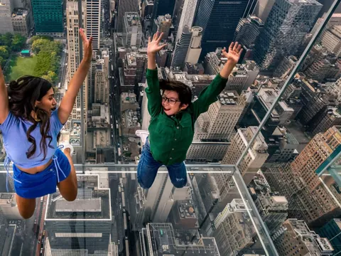 Personas saltando en la habitación de cristal del Summit One Vanderbilt