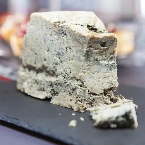 Cuña de Queso de Cabrales, un queso azul típico de Asturias, España, servido sobre una tabla negra.