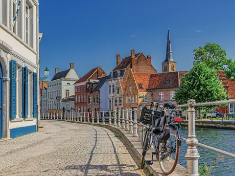 Bicicleta aparcada junto a un canal en el casco antiguo de Brujas, Bélgica.