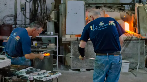 Artesanos trabajando vidrio soplado en un taller tradicional de Murano, Venecia