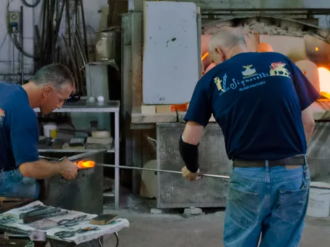 Artesanos trabajando vidrio soplado en un taller tradicional de Murano, Venecia