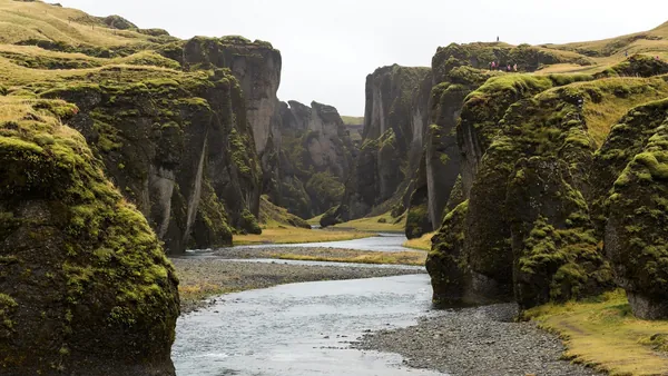 Cañón Fjaðrárgljúfur en el Parque Nacional Vatnajökull, Islandia, con paredes cubiertas de musgo y río serpenteante.