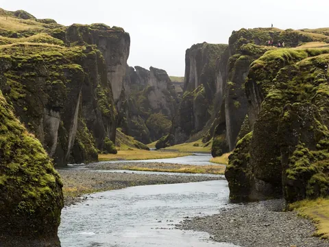 Cañón Fjaðrárgljúfur en el Parque Nacional Vatnajökull, Islandia, con paredes cubiertas de musgo y río serpenteante.