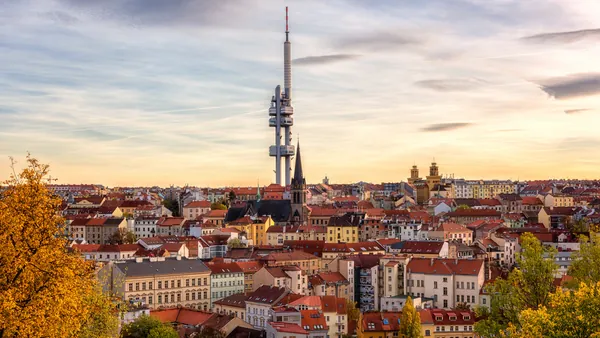 Vista panorámica de la Torre de Televisión Žižkov sobre los tejados de Praga al atardecer.