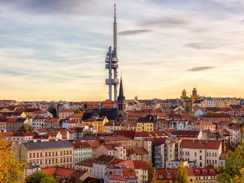 Vista panorámica de la Torre de Televisión Žižkov sobre los tejados de Praga al atardecer.