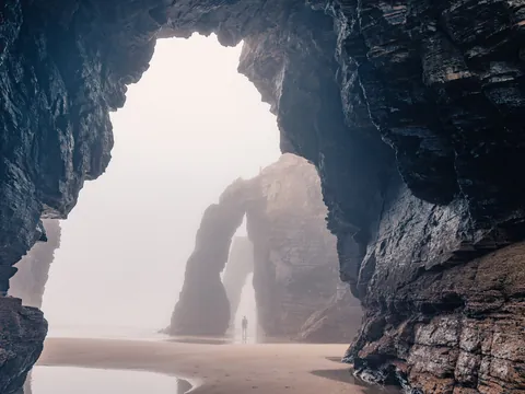 Vista interior de las cuevas y arcos naturales de la Playa de las Catedrales en un día de niebla, en la costa de Galicia.