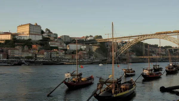Barcos rabelos frente al puente de Don Luis I al atardecer en Oporto.