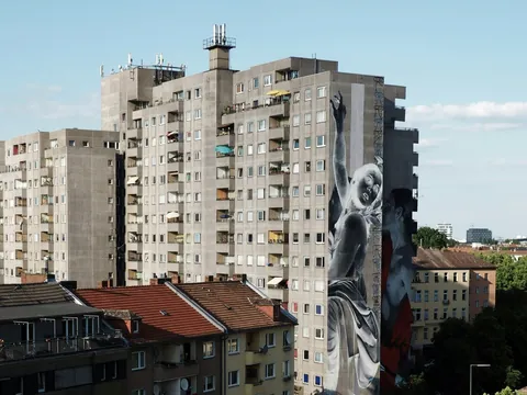 Edificio de apartamentos en Berlín con gran mural artístico en la fachada lateral.